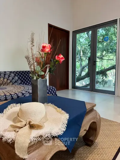 Charming living room with stylish decor and garden view, perfect for relaxation.