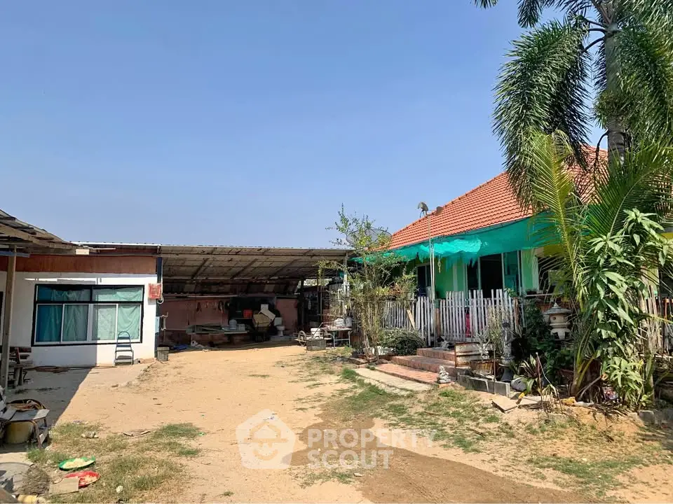 Charming rural property with spacious yard and traditional architecture under clear blue skies.