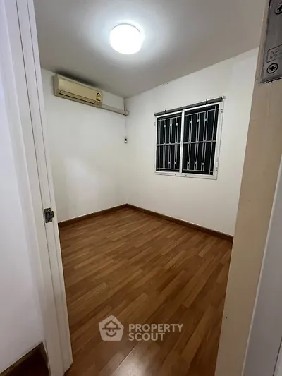 Cozy small room with wooden flooring and air conditioning, perfect for a compact living space.