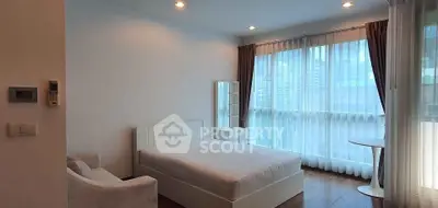 Bright and airy bedroom with modern decor and large windows in urban apartment