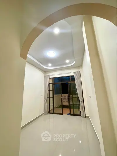 Spacious interior with high ceiling and large windows leading to a balcony, perfect for natural light.