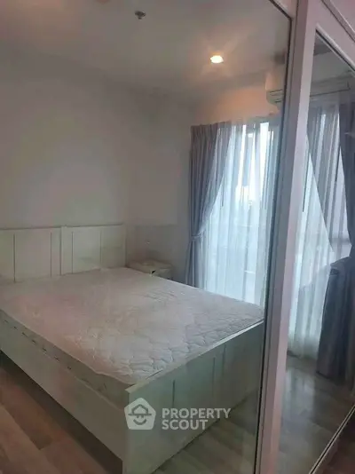 Cozy bedroom with large window and elegant curtains, perfect for relaxation and comfort.