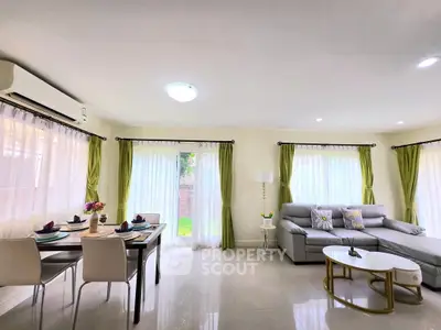 Spacious living room with elegant dining area and modern decor, perfect for family gatherings.