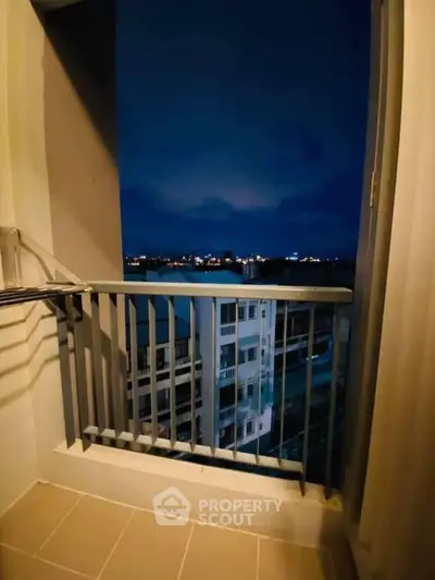 Charming balcony with stunning night view of city skyline, perfect for relaxation and enjoying the evening breeze.