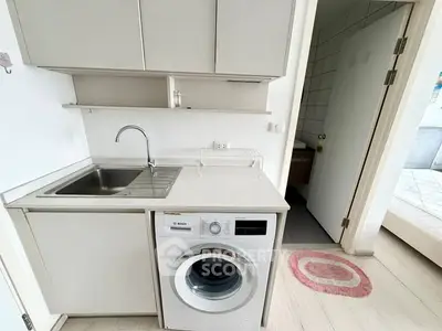 Compact kitchen with washing machine and sink in modern apartment