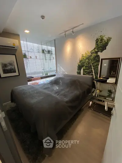 Modern bedroom with stylish decor and natural light, featuring a cozy bed and artistic wall design.