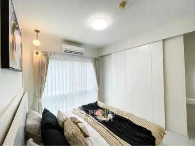 Cozy and bright bedroom with modern decor and large window for natural light.