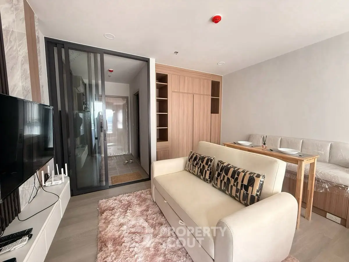 Modern living room with stylish sofa and dining area in open layout apartment.