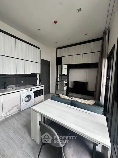 Modern kitchen with washing machine and open layout in stylish apartment.