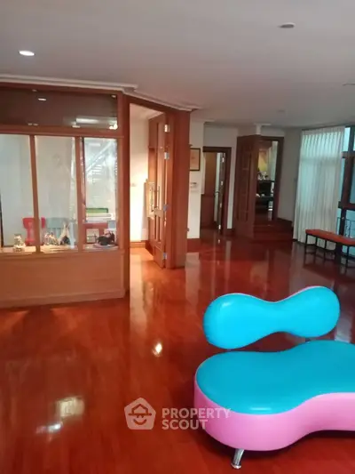 Spacious interior with polished wooden floors and modern seating, perfect for stylish living.