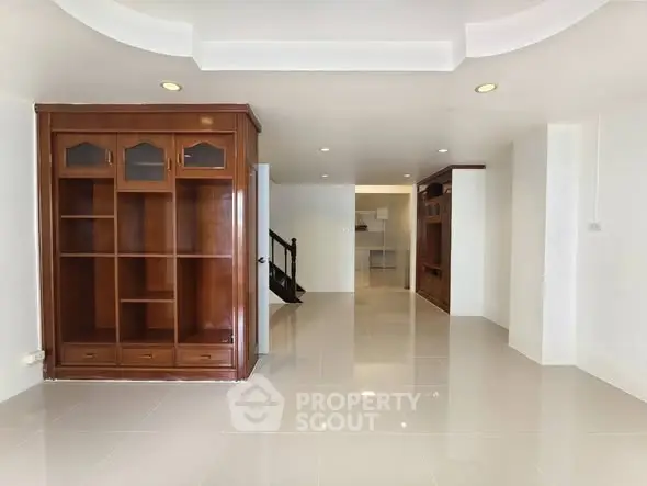 Spacious living room with elegant wooden shelving and modern tile flooring