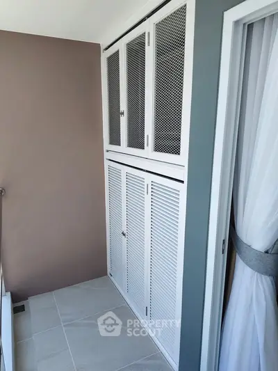 Stylish balcony with modern storage cabinets and elegant curtain design.