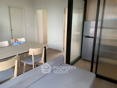 Modern apartment interior with dining area and cozy seating, featuring sleek design and neutral tones.