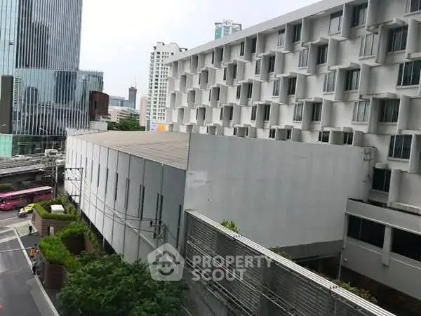 Modern urban building exterior with unique architectural design in bustling cityscape.