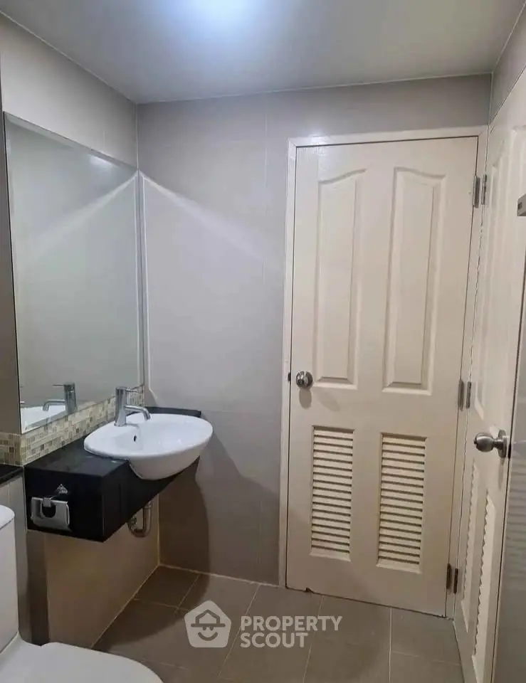 Modern bathroom with sleek sink and neutral tiles, perfect for a contemporary home.