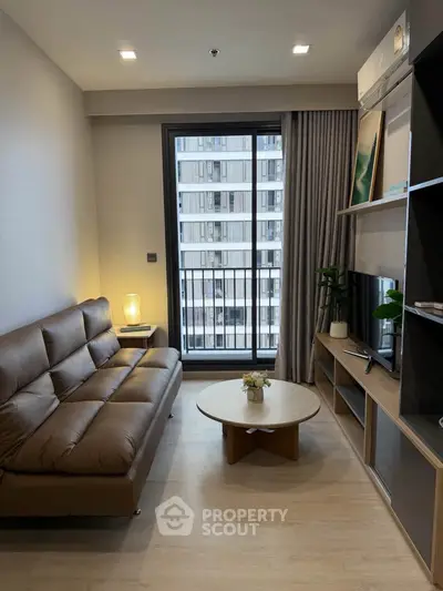 Modern living room with leather sofa, TV, and balcony view in a stylish apartment.