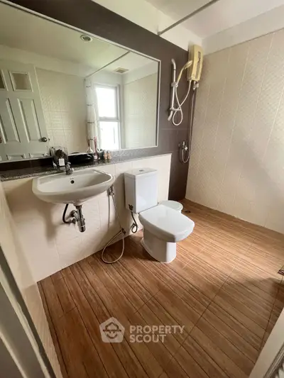 Modern bathroom with wooden flooring and large mirror