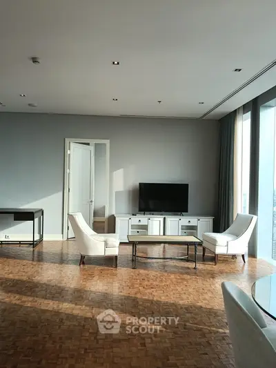 Spacious living room with elegant furniture and large windows offering natural light.