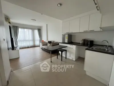 Modern open-layout kitchen and living room with sleek design and natural light.