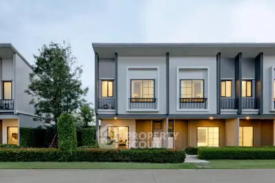 Modern townhouse exterior with lush landscaping and large windows