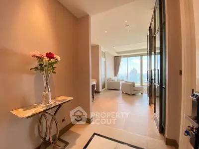 Luxurious apartment entrance leading to a spacious living room with stunning city views.