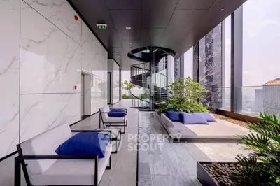 Luxurious high-rise building balcony with modern seating and stunning city views.