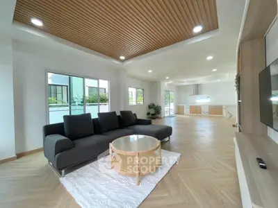 Spacious modern living room with sleek furniture and open kitchen layout