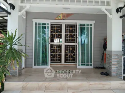 Charming entrance with decorative glass doors and tiled porch