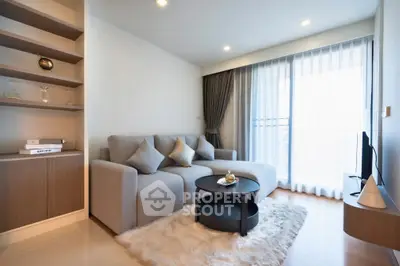 Modern living room with cozy sofa, stylish decor, and natural light from large windows.