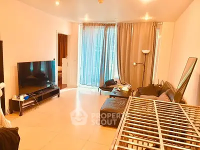 Spacious living room with modern decor and large TV, perfect for relaxation.
