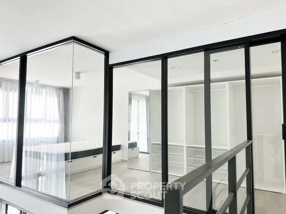 Modern bedroom with glass walls and minimalist design in a contemporary apartment.