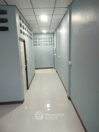 Spacious hallway with modern lighting and sleek design, perfect for residential or commercial use.