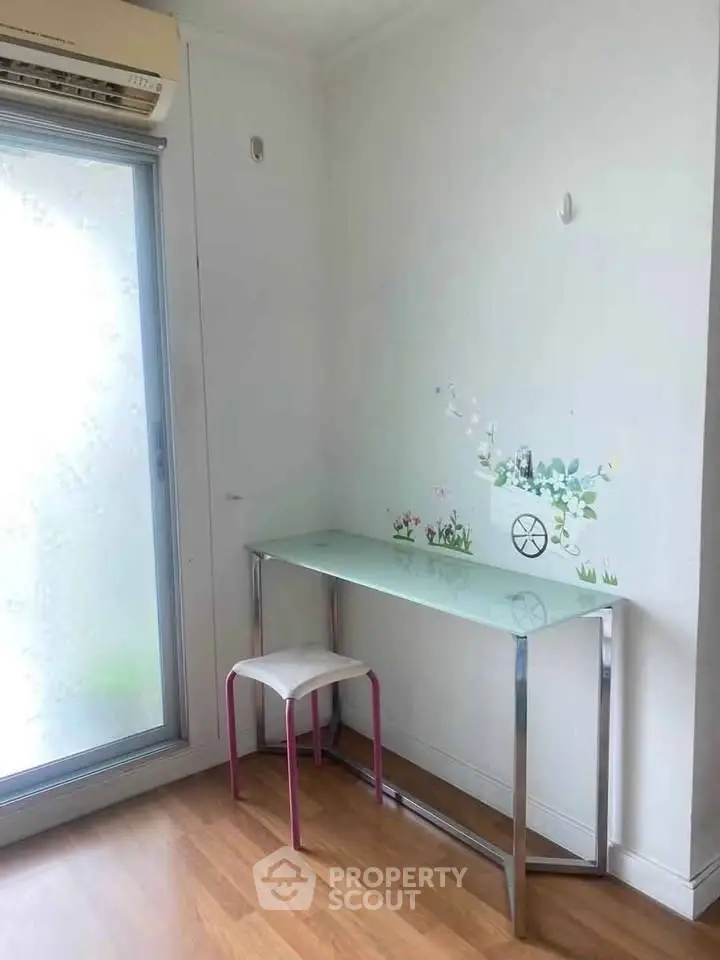 Bright study nook with glass desk and stool, perfect for productivity in a modern home.