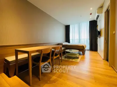 Modern studio apartment with wooden flooring and natural light