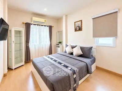 Modern bedroom with stylish decor and natural light, featuring a cozy bed and elegant furnishings.