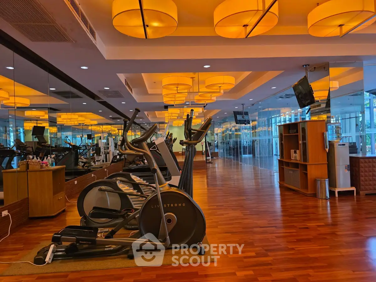 Luxurious gym with modern equipment and stylish lighting in upscale real estate property.