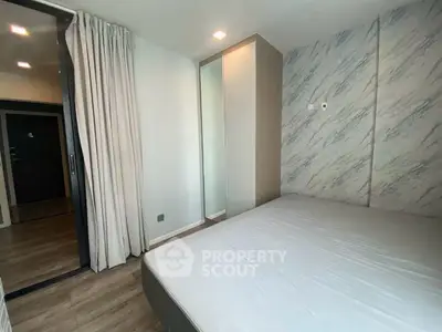 Modern bedroom with stylish decor and mirrored wardrobe in a contemporary apartment.