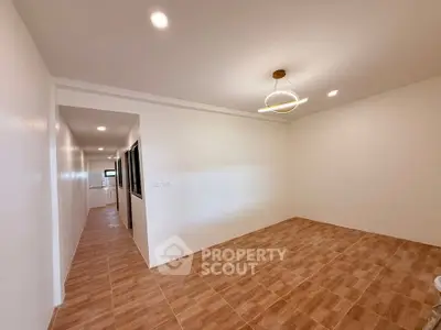 Spacious unfurnished room with modern lighting and tiled flooring, perfect for customization.