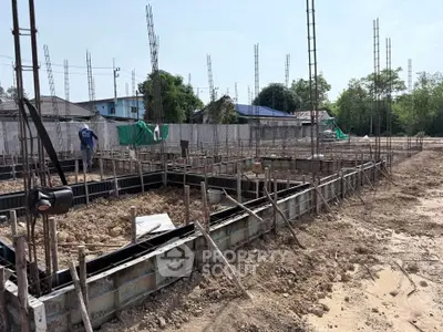 Construction site with foundation work and steel reinforcements for new building development.