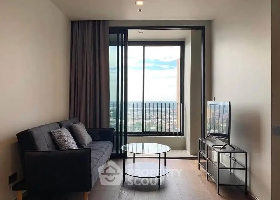 Modern living room with large window offering stunning city view, sleek furniture, and cozy ambiance.