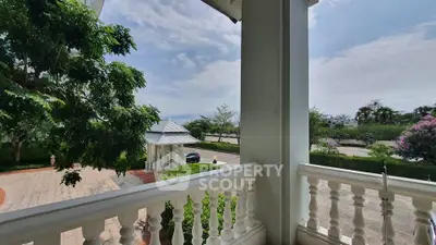 Charming balcony view overlooking lush greenery and serene surroundings in a luxurious estate.