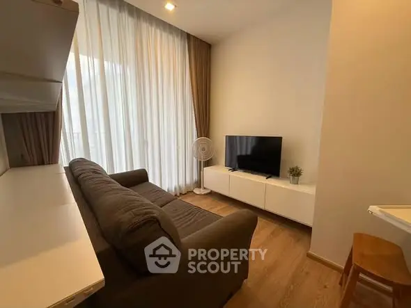 Cozy living room with modern decor, featuring a comfortable sofa and flat-screen TV, perfect for relaxation.