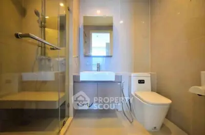 Modern bathroom with glass shower and sleek fixtures in a contemporary home.