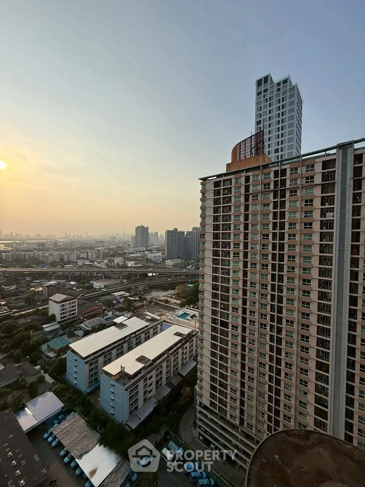 Stunning cityscape view from high-rise building at sunset, showcasing urban living.