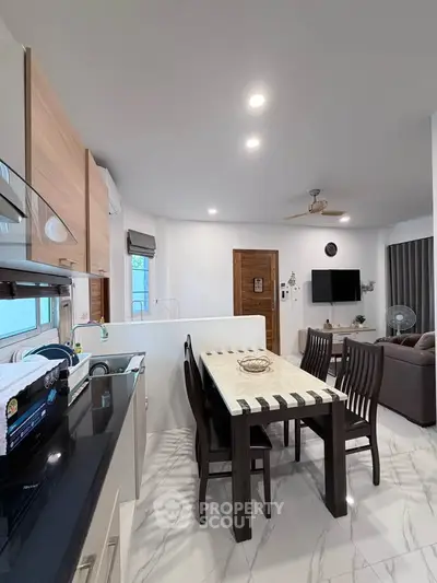 Modern open-layout living room with dining area and sleek kitchen design