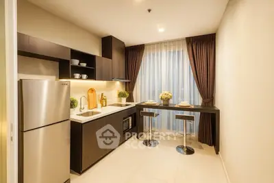 Modern kitchen with sleek cabinetry and breakfast bar in cozy apartment.