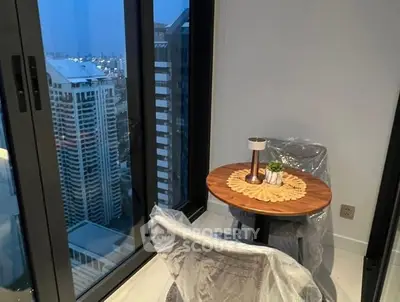 Cozy balcony with city view, featuring a small table and chairs, perfect for relaxation.