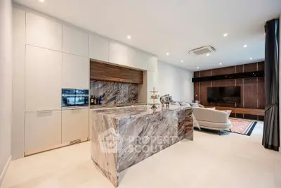 Luxurious open-plan kitchen and living area with marble island and modern appliances.