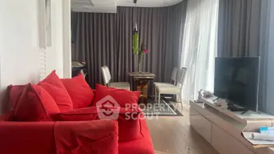 Modern living room with vibrant red sofa and elegant dining area, featuring floor-to-ceiling windows and stylish decor.