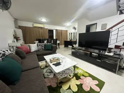 Spacious living room with modern decor and large TV, perfect for family gatherings.